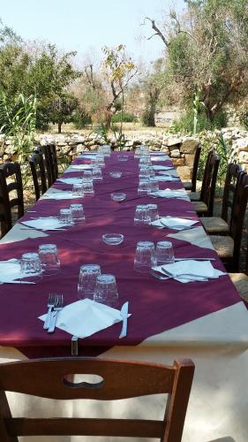 a long table with plates and forks and napkins at Agriturismo Tenuta La Siesta in Gallipoli