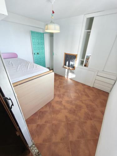 a bedroom with a bed and a tile floor at Beach house in Rincón de la Victoria
