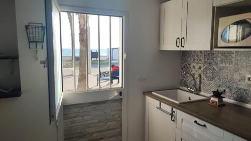 a kitchen with a sink and a window with a view of the ocean at Beach house in Rincón de la Victoria