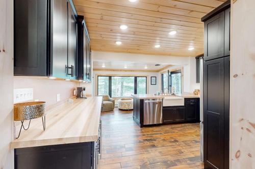 a kitchen with black cabinets and a counter top at River House in North Creek