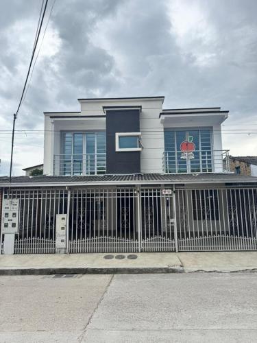 a white house with a fence in front of it at Apartamento 201 - a 5 minutos del centro de Pitalito in Pitalito