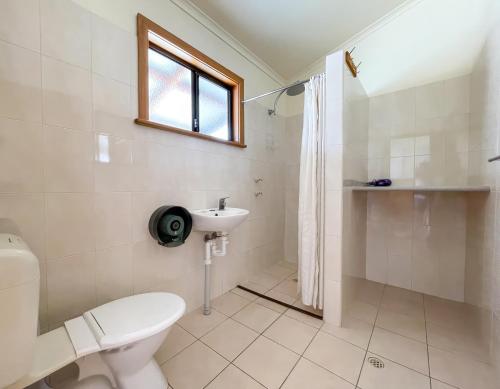 a white bathroom with a toilet and a sink at Tumby Bay Caravan Park in Tumby Bay