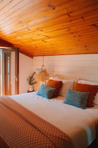 a bedroom with a large bed with a wooden ceiling at Casa com 4 quartos e Jardim Espaçoso - Santa Sofia in Moledo