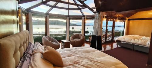 a living room with a swinging bed and a large window at Los uros Isla atardecer in Puno