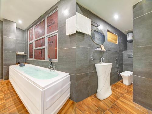 a bathroom with a large tub and a sink at Hotel The Arrow International Laxmi Nagar in New Delhi