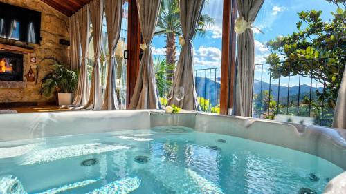 a hot tub in a room with a large window at Casa Favo de Mel - Piscina & Jacuzzi Privado - Lareira in Arcos de Valdevez