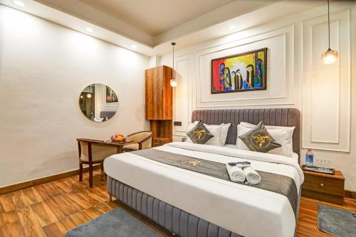 a bedroom with a large bed and a table at Hotel The Arrow International Laxmi Nagar in New Delhi