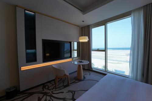 a hotel room with a table and a large window at Hills HOTEL - فندق هيلز in Al Khobar