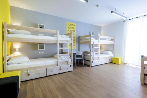 a room with three bunk beds and a desk at Hostel EuroAdria in Dubrovnik