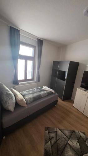 a bedroom with a large bed and a window at Suite Calli in Bernburg