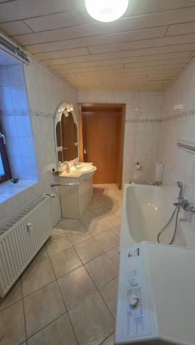 a large bathroom with a tub and a sink at Suite Calli in Bernburg
