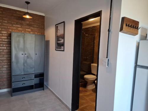 a bathroom with a toilet and a glass cabinet at Terrazas del Monte in San Miguel del Monte