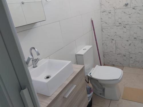 a white bathroom with a sink and a toilet at Pousada sushi-lazer in Casa Branca