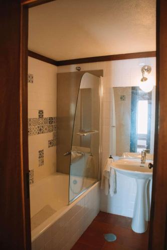 a bathroom with a shower and a tub and a sink at Casa com 4 quartos e Jardim Espaçoso - Santa Sofia in Moledo