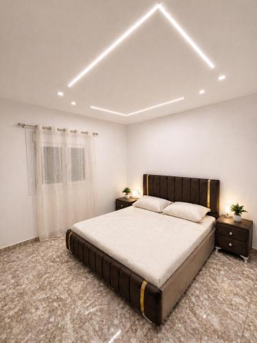 a bedroom with a large bed and two night stands at Dar Essalam - Mostaganem, Salamandre in Mostaganem