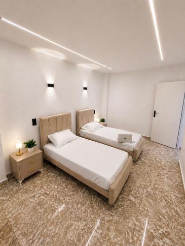 a bedroom with two beds and a laptop on a table at Dar Essalam - Mostaganem, Salamandre in Mostaganem