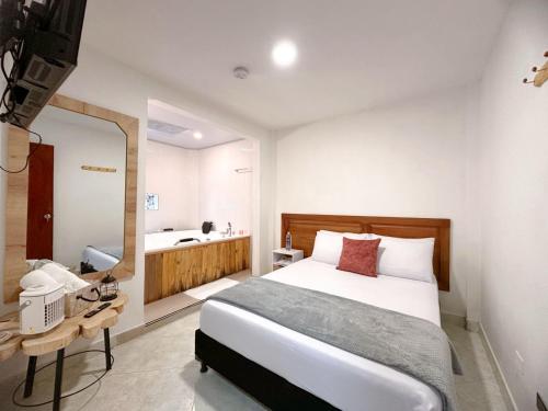a bedroom with a bed and a mirror and a bathroom at Hostal Rose Moor in Jardin