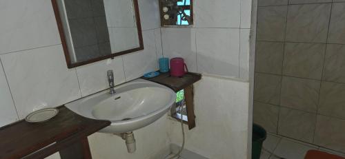a small bathroom with a sink and a mirror at MAHAMBO BEACH hôtel in Mahambo