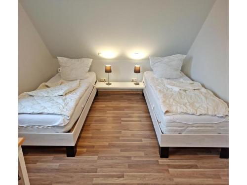 two beds sitting next to each other in a room at Deichhuus in Neßmersiel in Neßmersiel