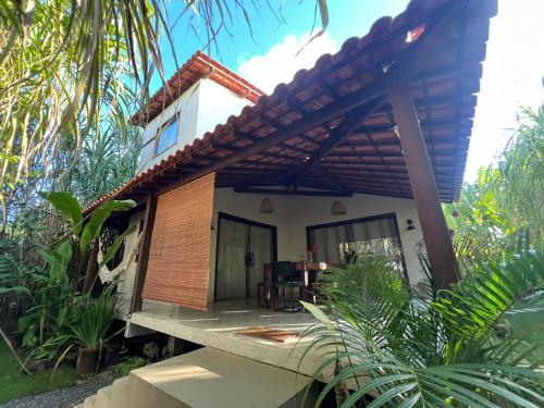 a house with a balcony with a roof at Casa Gemini in Ilha de Boipeba