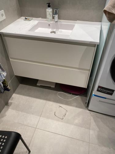a bathroom with a white sink on a tiled floor at Eskias2 in Garðabær