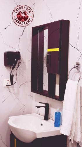 a bathroom with a sink and a mirror on the wall at Rum Rhal Luxury Camp in Aqaba