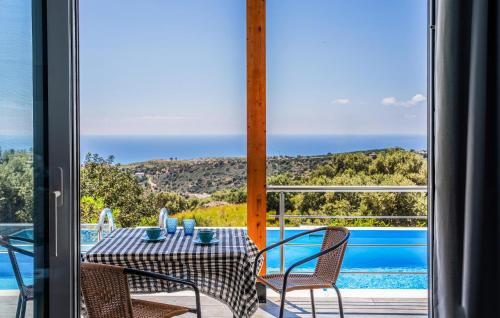 a table and chairs on a balcony with a view of a pool at Daphne 2 in Agia Galini