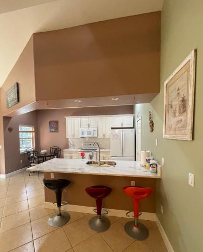 a kitchen with two bar stools and a sink at Pool Home in Englewood