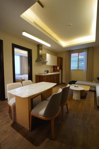 a living room with a table and chairs at Hills HOTEL - فندق هيلز in Al Khobar