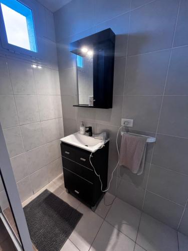 a bathroom with a sink and a shower with a mirror at Urbano Alem in Coronel Suárez