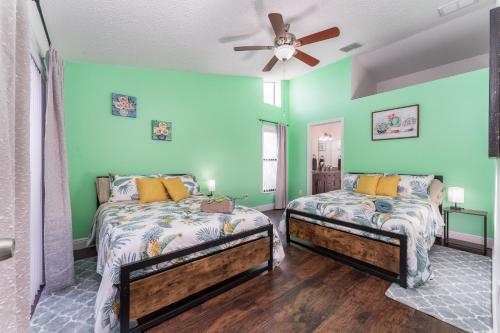 two beds in a room with green walls at The Pelican/Pool/HotTub/GameRoom in Brandon