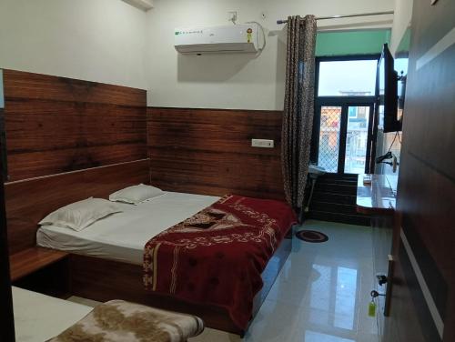 a small bedroom with a bed and a window at Well come hotel in Baori Thikria