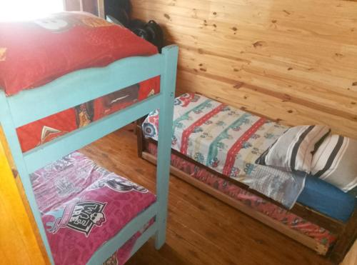 a small bunk bed in a room with a wooden wall at Rincón Entrerriano in Concepción del Uruguay