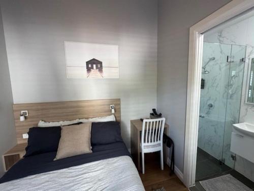 a bedroom with a bed and a bathroom with a sink at Carnarvon Lodge Kirribilli, Sydney in Sydney