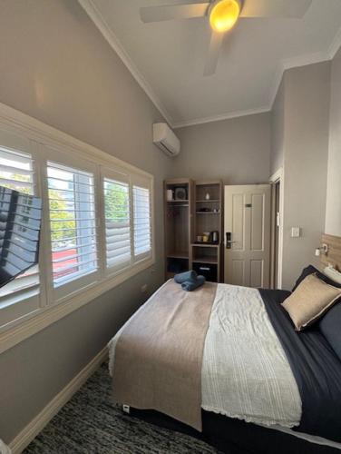 a bedroom with a bed and a ceiling fan at Carnarvon Lodge Kirribilli, Sydney in Sydney