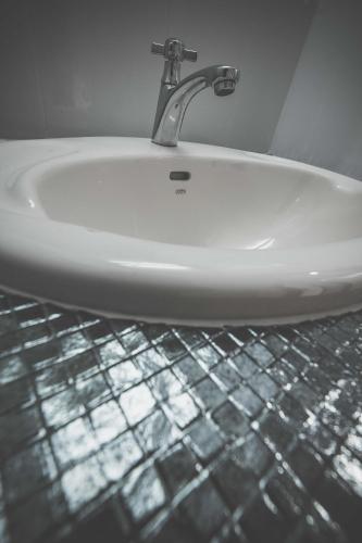 a sink with a faucet in a bathroom at Don Muang Hotel in Bangkok