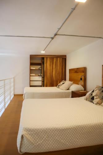 a bedroom with two beds at Calle y Número, San Felipe in Guadalajara