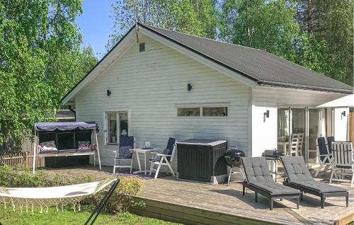 a house with a deck with chairs and a grill at Amazing Home In Luleå With Sauna in Luleå