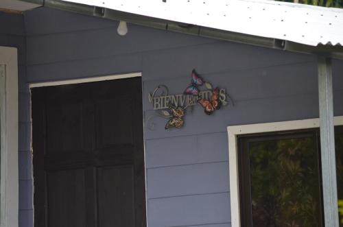 a house with a sign on the side of it at Hummingbird Morfus Lodge in Tilarán