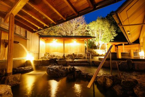 a house with a pond with rocks in it at Sun Urashima Yuki no Sato in Toba