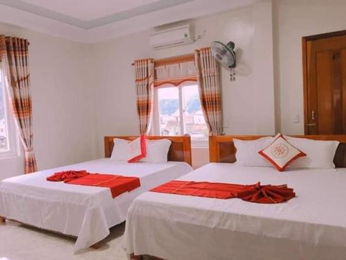 a bedroom with two beds with red sheets at An Binh Homestay in Phong Nha