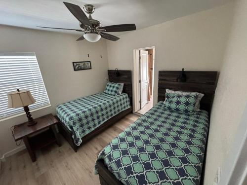 a bedroom with a bed and a ceiling fan at Coastal Sun Retreat in St. Pete Beach