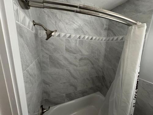a bathroom with a shower with a white shower curtain at Coastal Sun Retreat in St. Pete Beach