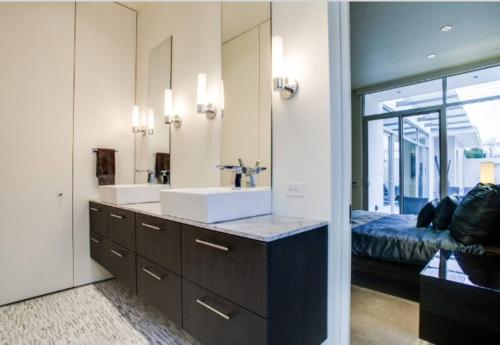 a bathroom with a sink and a large mirror at Luxury 2BR 2BA w Pool and Large Pets Allowed in Dallas