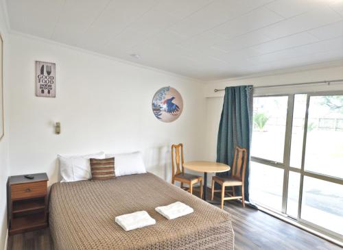 a bedroom with a bed and a table with chairs at Golden Aura Suites in Stratford