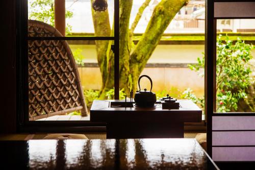 a tea kettle sitting on a table in front of a window at Ryoutei Ryokan Yasui in Hikone