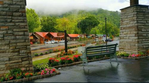 a park bench in front of a town with flowers at Rolling Hills Lodge in Cherokee