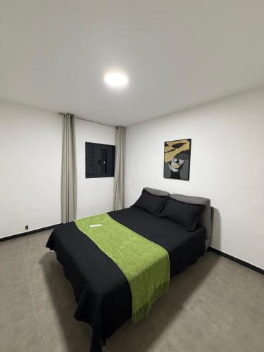 a bedroom with a bed with a green blanket at Blanquila Resort in Willemstad