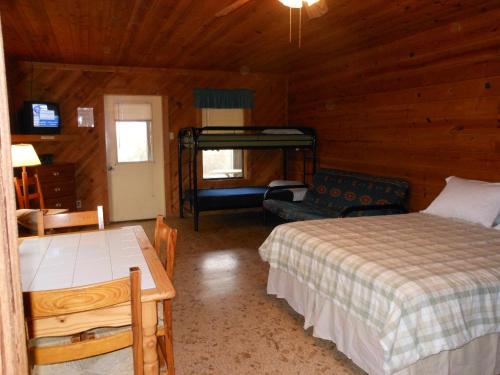 een slaapkamer met 2 bedden en een bank in een hut bij Bay Landing Camping Resort Deluxe Cabin 29 in Bridgeport