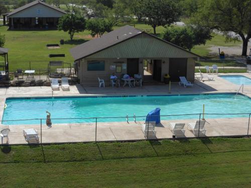a large swimming pool with chairs and a house at Bay Landing Camping Resort Deluxe Cabin 29 in Bridgeport